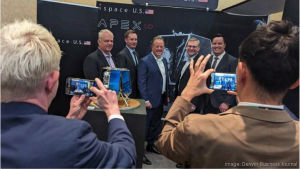 Executives with Denver-based iSpace U.S.A. and Lafayette-based BCT, an RTX subsidiary, gather next to a model of the Apex 1.0 lunar lander during the companies' partnership announcement April 9, 2024, at the Space Symposium conference in Colorado Springs.